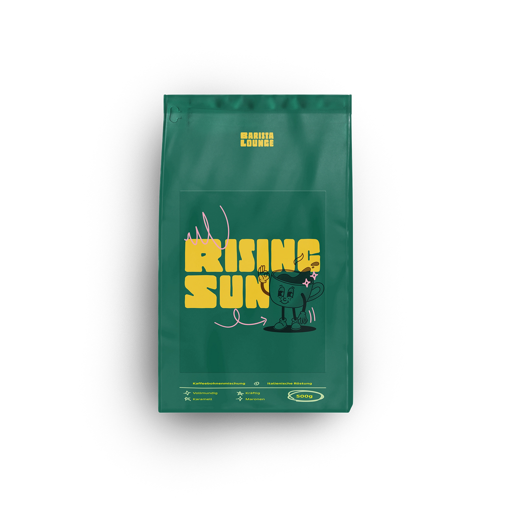 Produktansicht der Barista Lounge Kaffeemischung 'Rising Sun'. Die grüne Kaffeeverpackung ist mit einem auffälligen gelben Logo 'Rising Sun' und einem Comic-Maskottchen verziert. Die Mischung bietet vollmundige Aromen mit Noten von Karamell und Maronen, geröstet nach italienischer Tradition